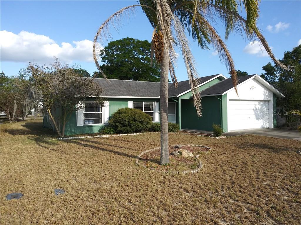 11018 Basquin Court Port Richey, FL 34668 - Photo 1 of 1 a house with trees in the background