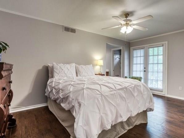 4000 Rawlins Street, Unit 101 Dallas, TX 75219 - Photo 18 of 27 a bedroom with a large bed and a chandelier