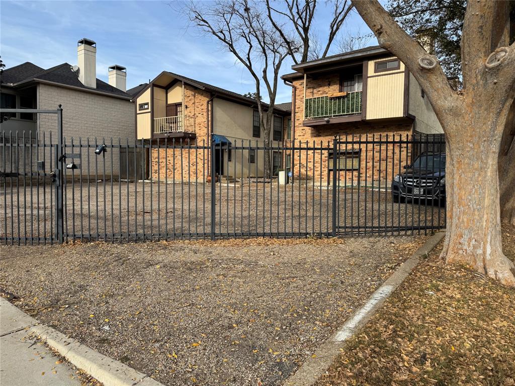 4000 Rawlins Street, Unit 101 Dallas, TX 75219 - Photo 27 of 27 a view of a house with a small yard and a large tree