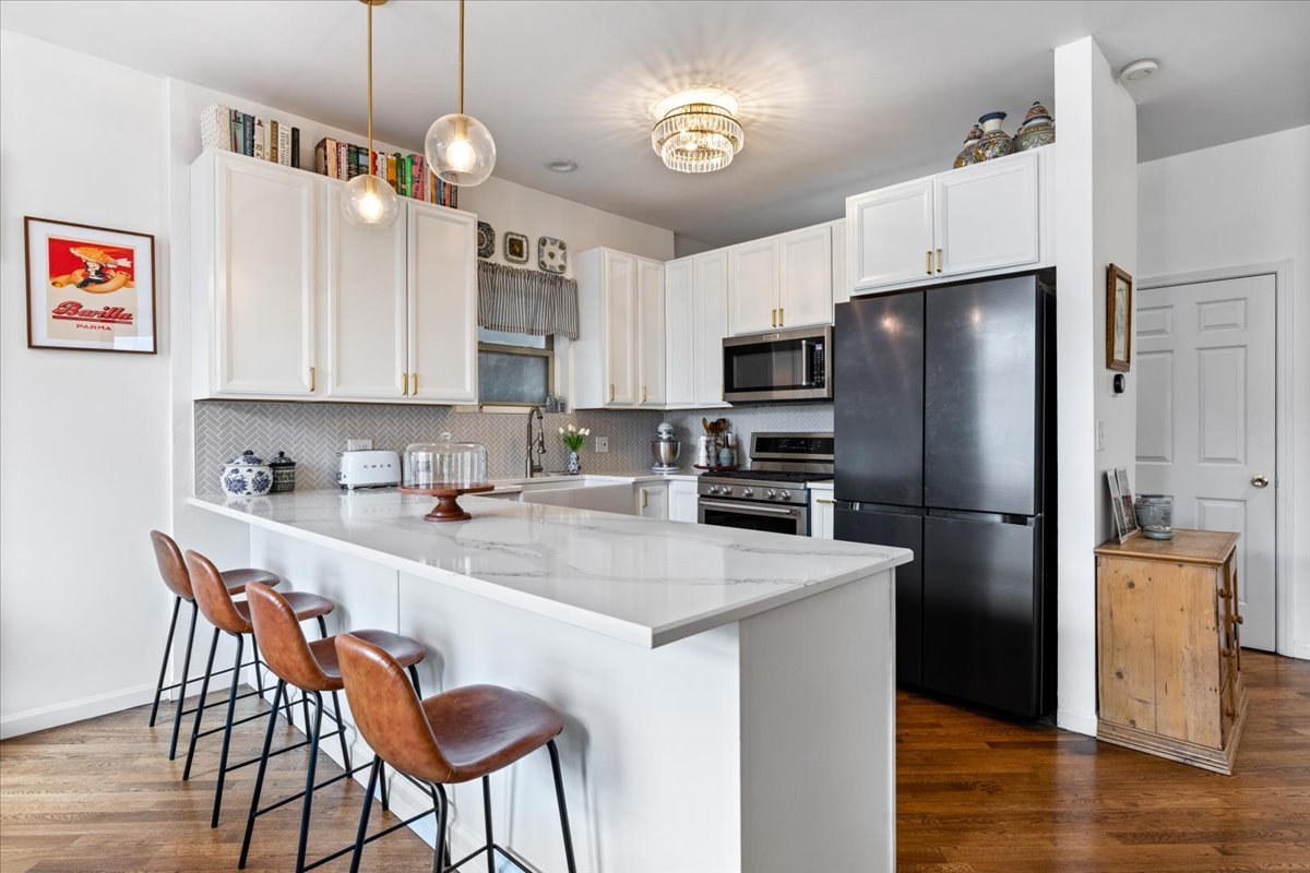 2121 West Division Street, Unit 1 Chicago, IL 60622 - Photo 9 of 18 a kitchen with stainless steel appliances granite countertop a refrigerator a sink a stove a dining table and chairs