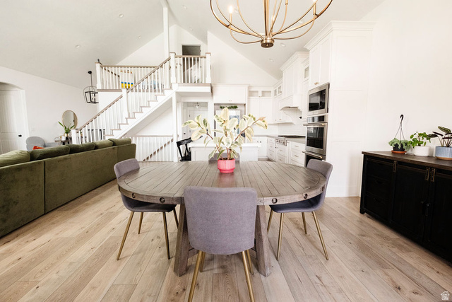 924 Country Lane Farmington, UT 84025 - Photo 15 of 91 Open-concept interior featuring light wood-finish flooring, vaulted ceilings, and a striking staircase with white risers and railings