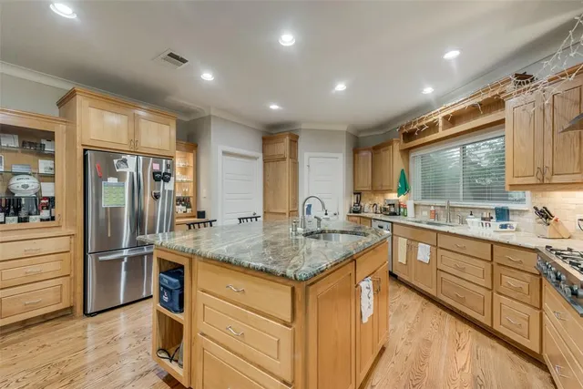 a kitchen with stainless steel appliances granite countertop a sink stove and refrigerator