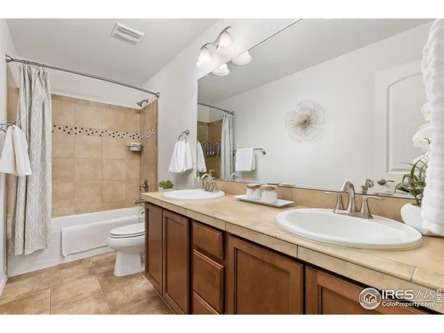 a bathroom with a granite countertop sink toilet a large mirror a shower and a bathtub