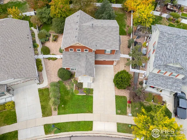 an aerial view of a house with swimming pool and large trees