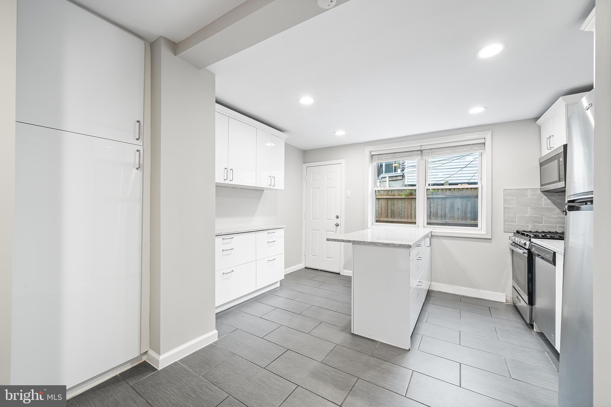 618 McClellan Street Philadelphia, PA 19148 - Photo 13 of 41 a kitchen with a refrigerator and white cabinets