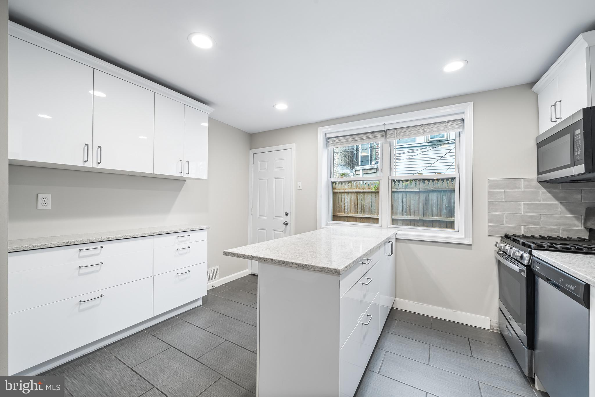 618 McClellan Street Philadelphia, PA 19148 - Photo 14 of 41 a kitchen with granite countertop white cabinets and white appliances
