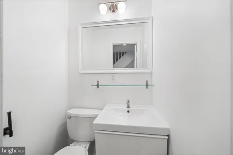 a bathroom with a toilet sink and mirror