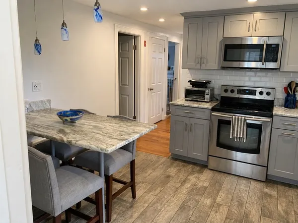 a kitchen with stainless steel appliances kitchen island granite countertop a stove a sink and a refrigerator