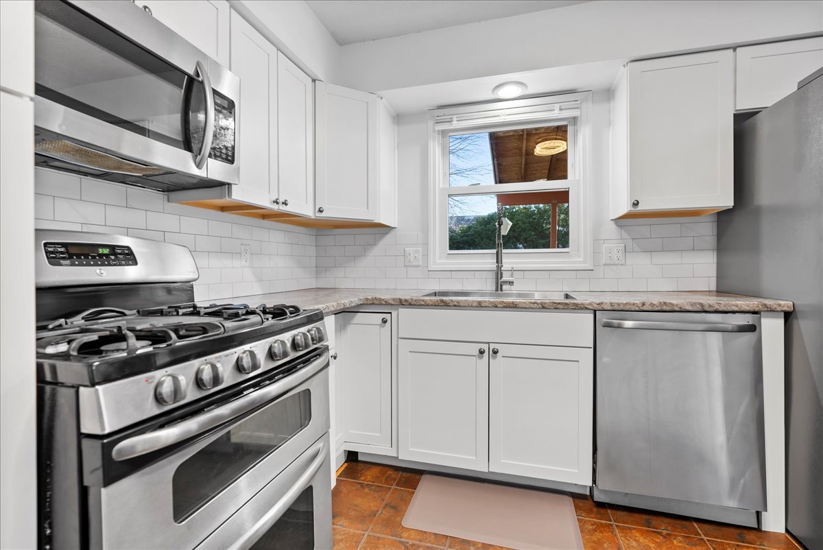 1421 Godfrey Drive Normal, IL 61761 - Photo 11 of 28 a kitchen with stainless steel appliances granite countertop a stove and a microwave