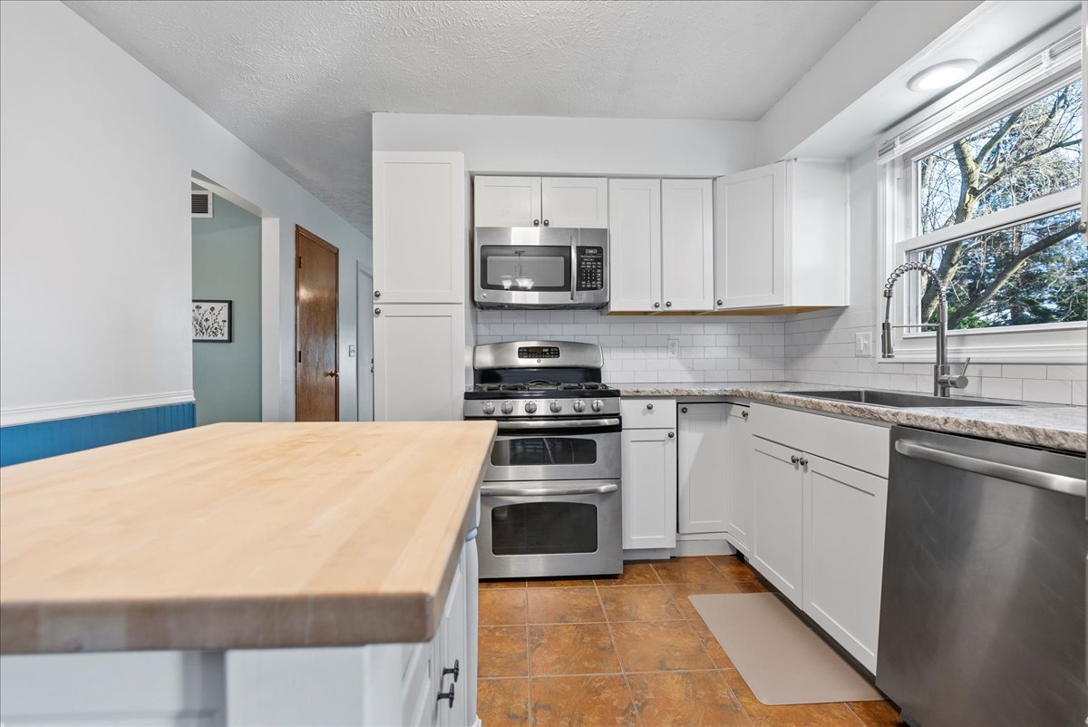 1421 Godfrey Drive Normal, IL 61761 - Photo 12 of 28 a kitchen with stainless steel appliances a stove microwave and sink