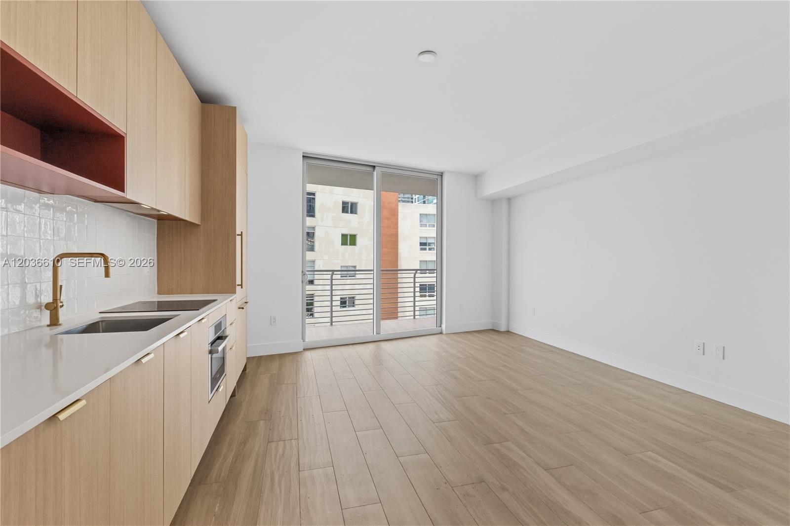 90 Northeast 32nd Street, Unit 1014 Miami, FL 33127 - Photo 39 of 39 a view of a kitchen with a sink and dishwasher with wooden floor