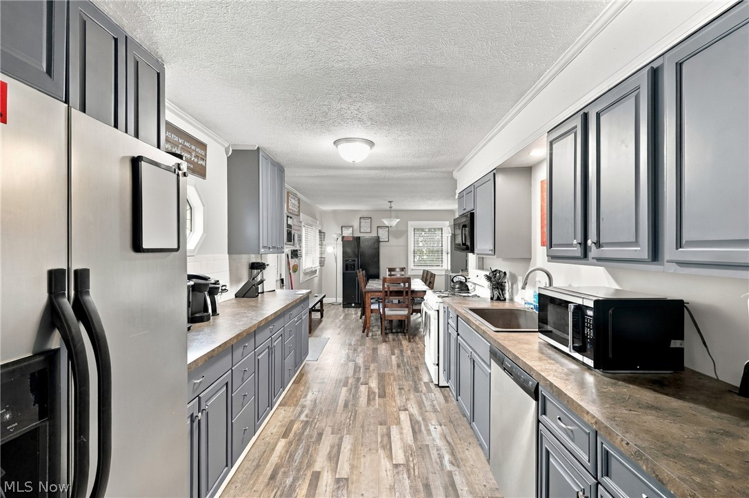 1875 Perth Road Madison, OH 44057 - Photo 31 of 48 Stainless steel refrigerator, gray shaker-style cabinetry, wood-finish flooring, recessed lighting, and a built-in dishwasher