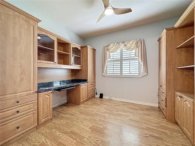 a view of an empty room with a window and a kitchen