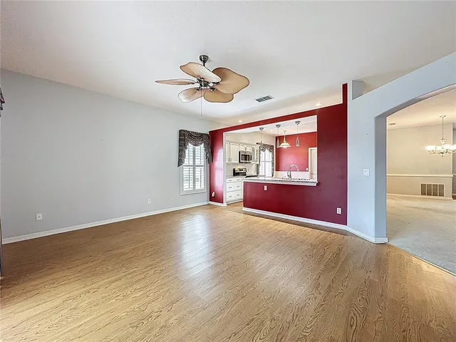 a kitchen with stainless steel appliances granite countertop a refrigerator a sink dishwasher a oven with white cabinets and wooden floor