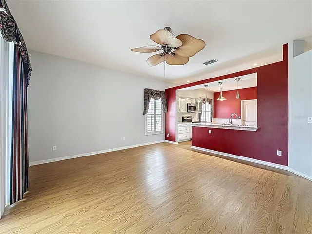 a view of a livingroom with a ceiling fan and window