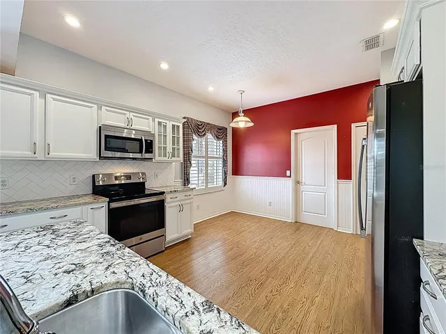a spacious bathroom with a granite countertop sink a toilet and a mirror