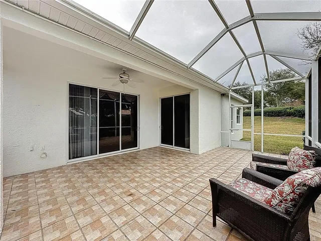 a living room with stainless steel appliances furniture a rug and a view of kitchen