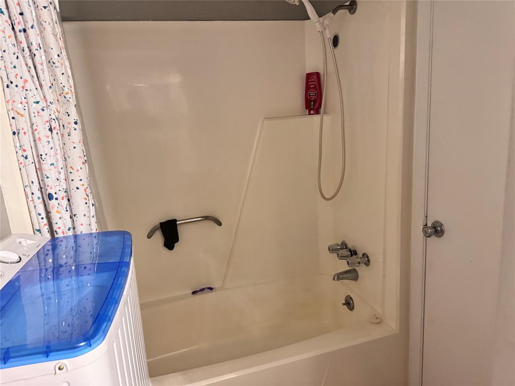 a bathroom with a bath tub with a shower