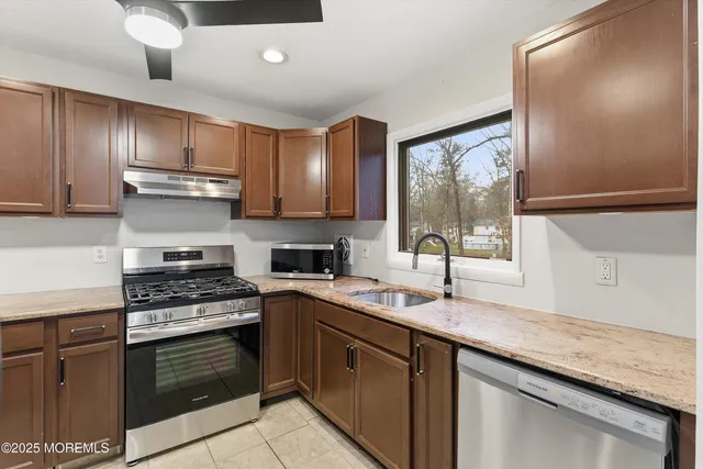 a kitchen with stainless steel appliances granite countertop a sink stove and oven