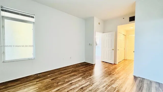 a view of a room with wooden floor and a window