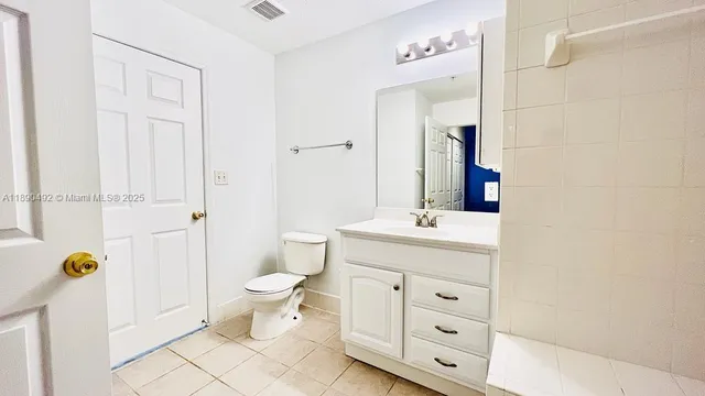 a bathroom with a toilet a sink a mirror and a shower