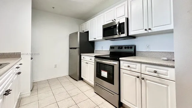 a kitchen with white cabinets stainless steel appliances and sink