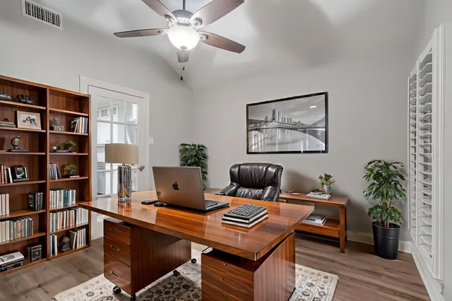 a living room with furniture a bookshelf and a potted plant