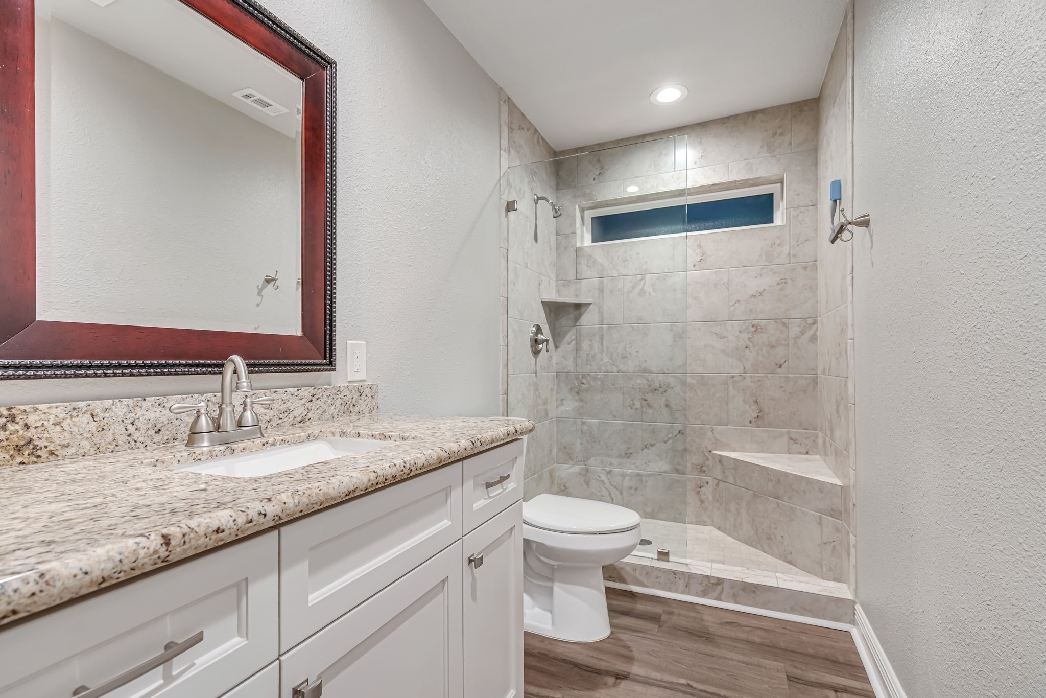 4702 Spring Lane Baytown, TX 77521 - Photo 21 of 34 a bathroom with a granite countertop sink a toilet and shower