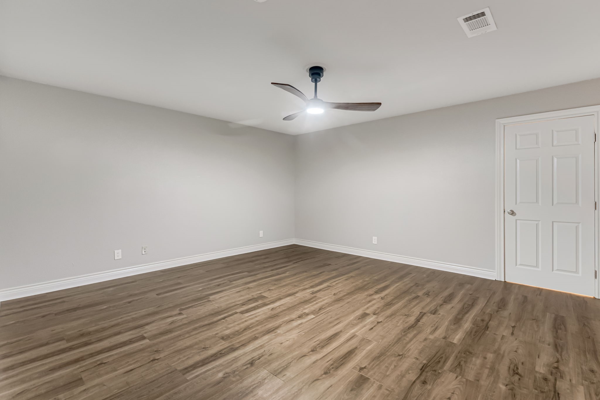 4702 Spring Lane Baytown, TX 77521 - Photo 24 of 34 an empty room with wooden floor and ceiling fan