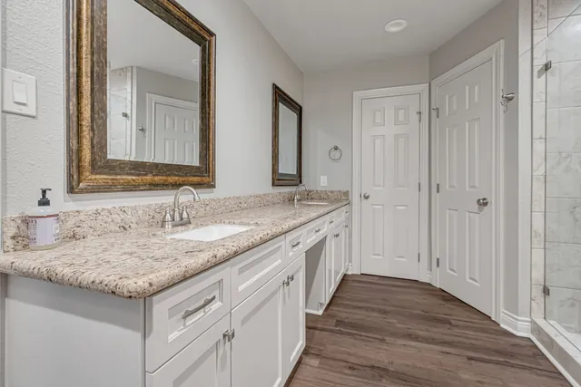 a bathroom with a granite countertop sink and a mirror