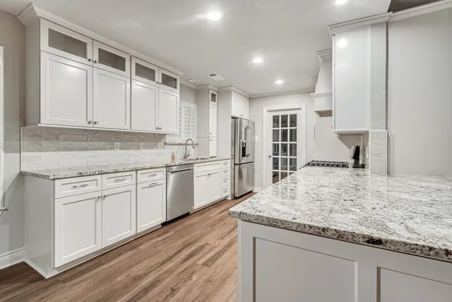 a kitchen with granite countertop cabinets stainless steel appliances and a counter space
