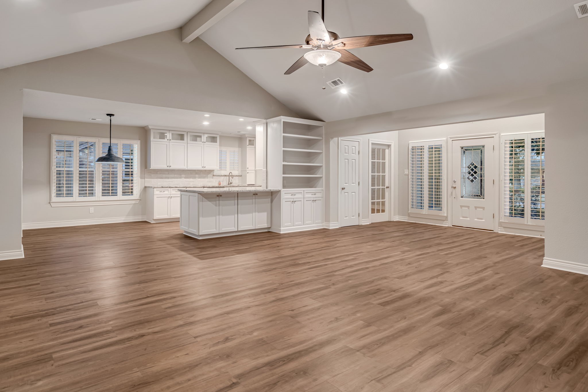 4702 Spring Lane Baytown, TX 77521 - Photo 6 of 34 an empty room with wooden floor and kitchen view