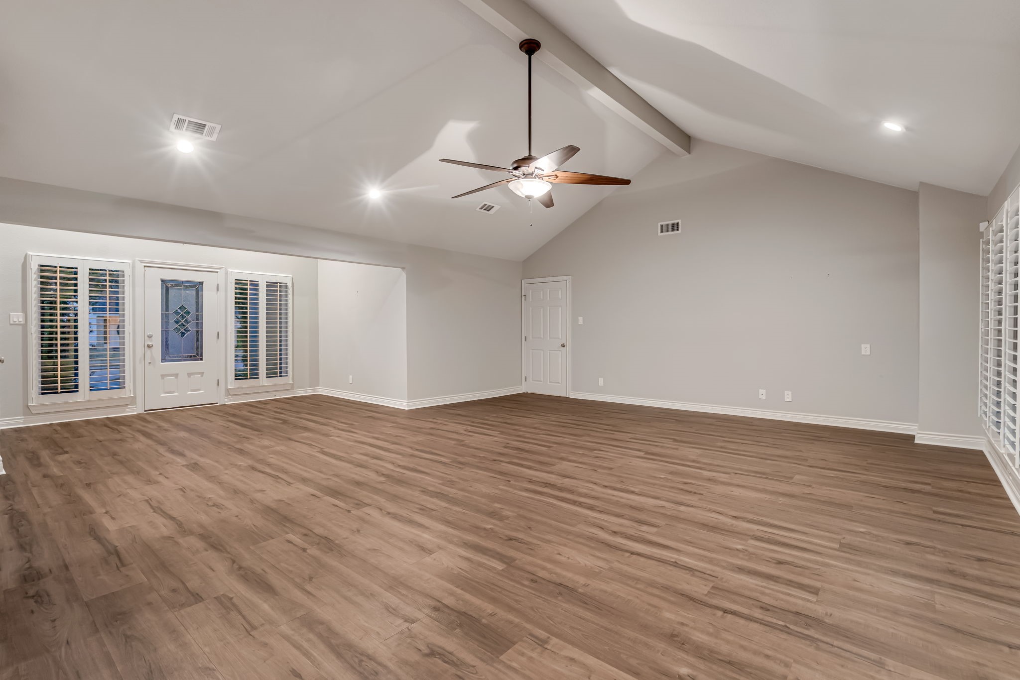 4702 Spring Lane Baytown, TX 77521 - Photo 7 of 34 a view of an empty room with wooden floor and a ceiling fan