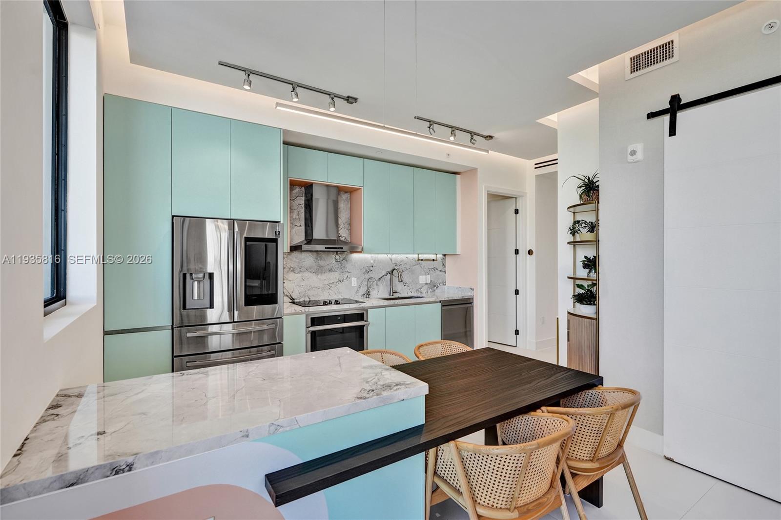 1030 15th Street, Unit PH5 Miami Beach, FL 33139 - Photo 12 of 38 a kitchen with a table and chairs in it