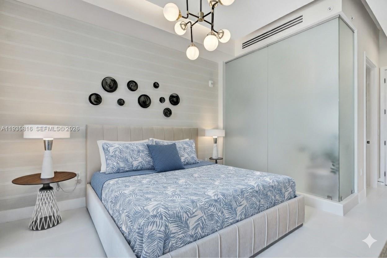 1030 15th Street, Unit PH5 Miami Beach, FL 33139 - Photo 3 of 38 a bedroom with a bed and a chandelier