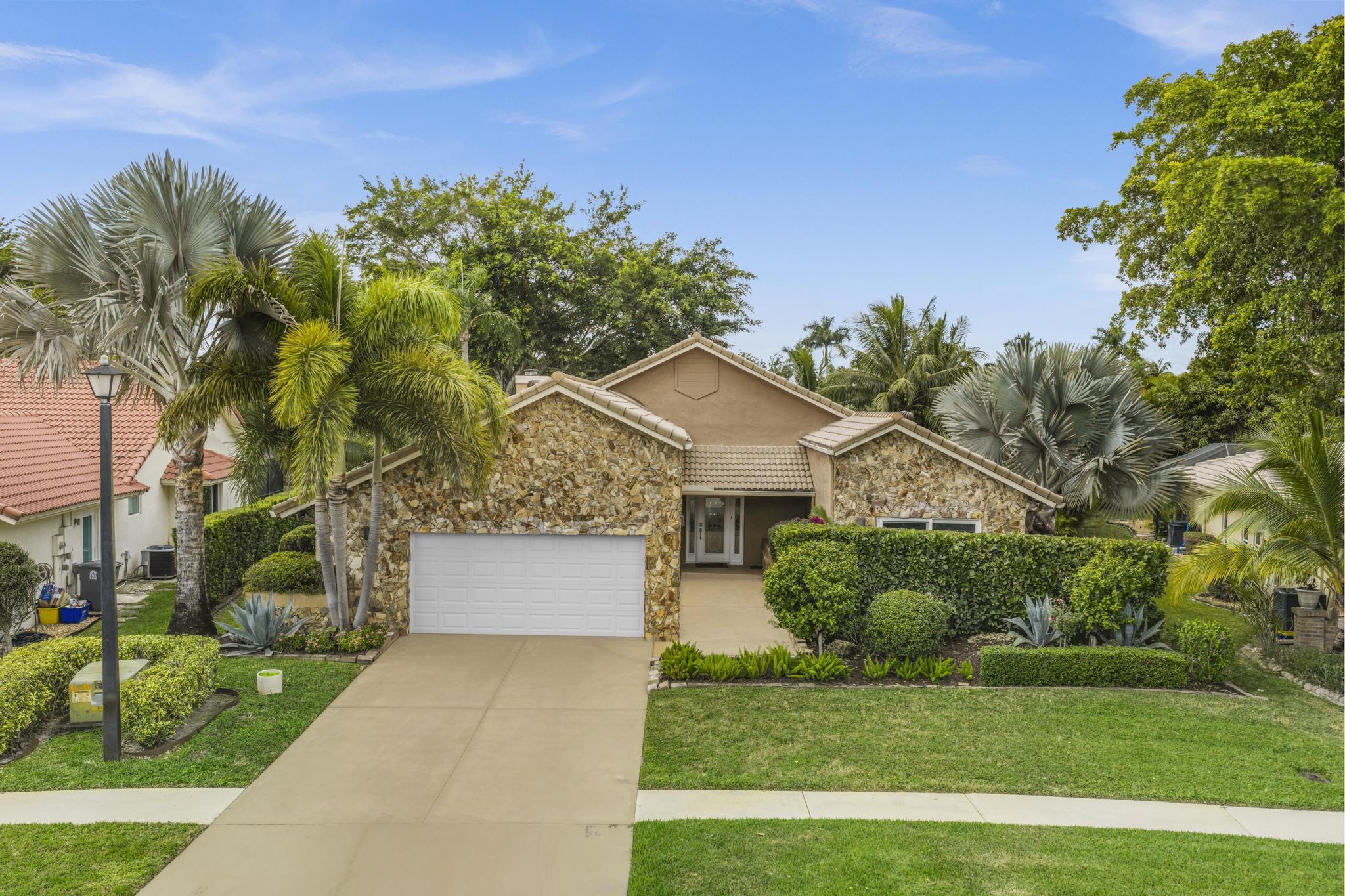 a front view of a house with a yard and potted plants