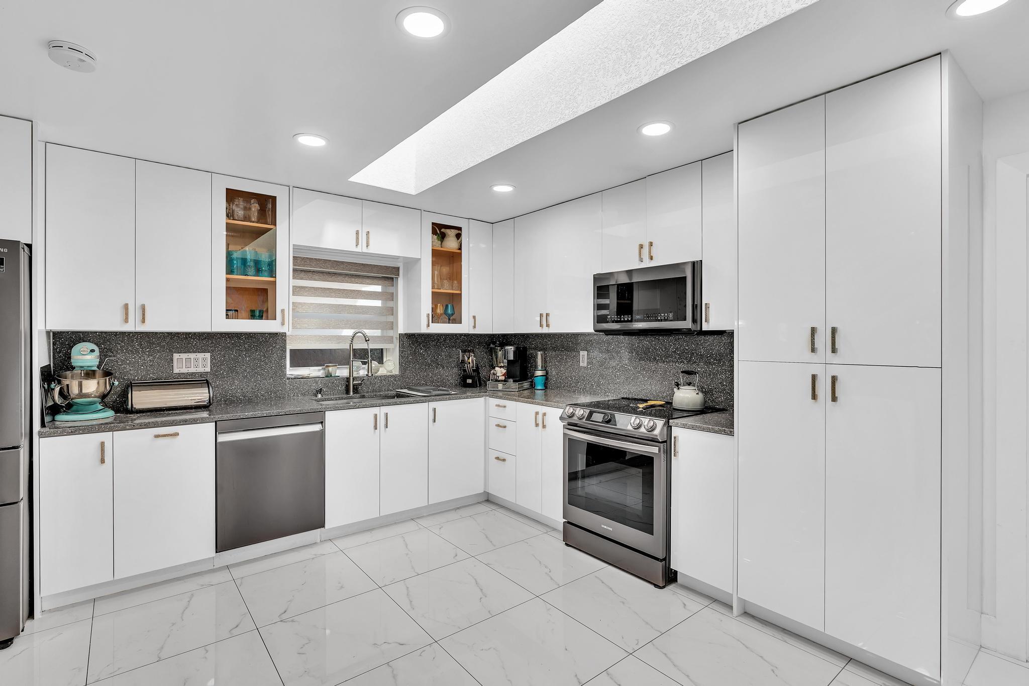 20104 Back 9 Drive Boca Raton, FL 33498 - Photo 21 of 78 a kitchen with granite countertop white cabinets and stainless steel appliances