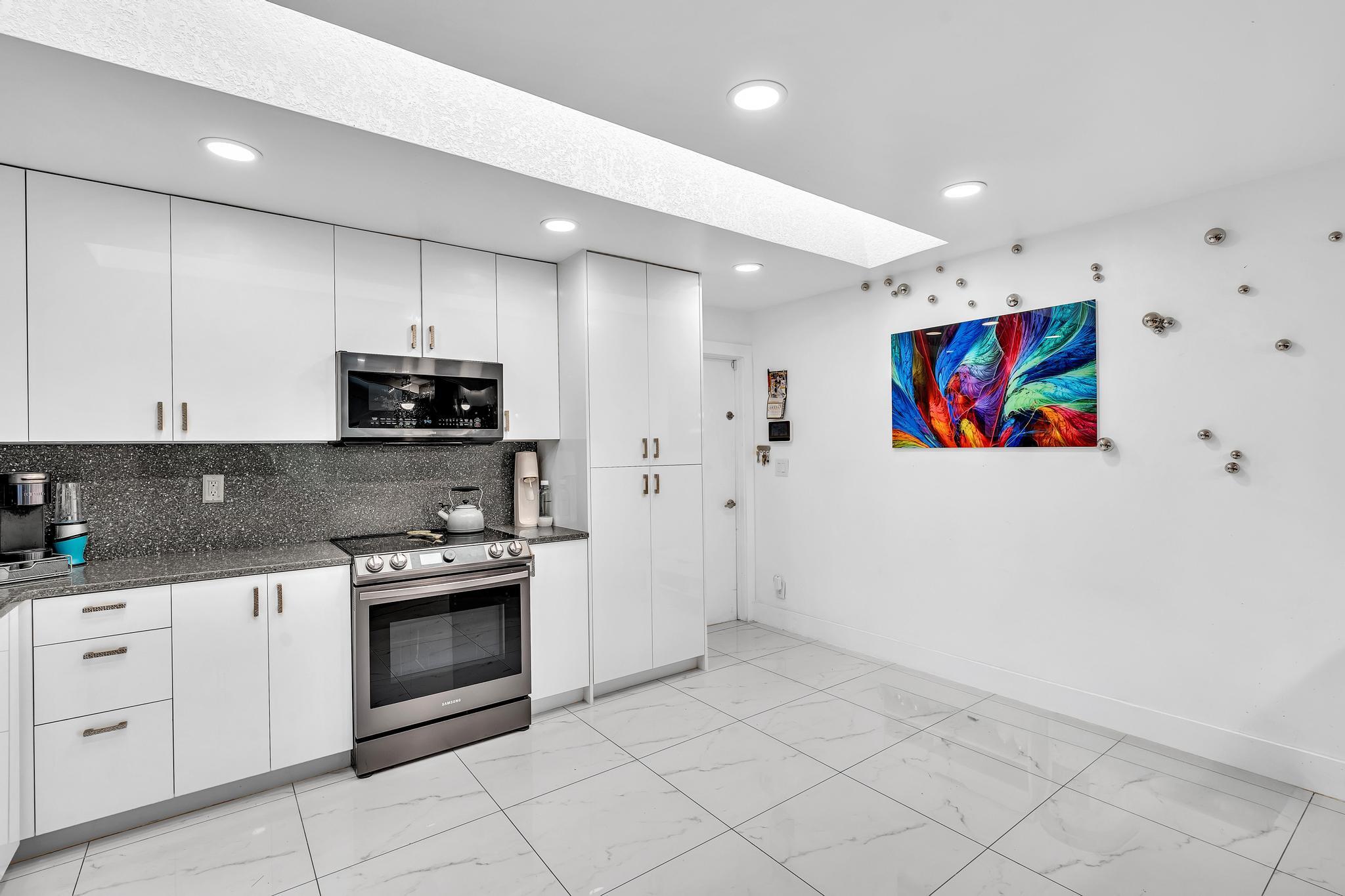 20104 Back 9 Drive Boca Raton, FL 33498 - Photo 22 of 78 a kitchen with stainless steel appliances granite countertop white cabinets a stove top oven and a sink