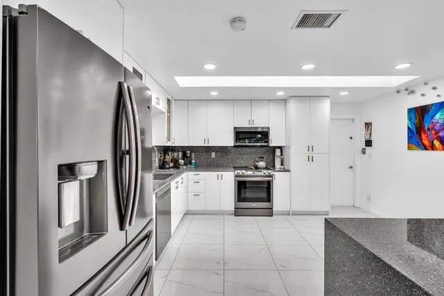 a kitchen with granite countertop a white table and chairs