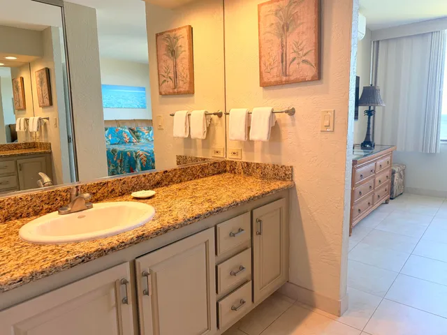 a bathroom with a granite countertop sink and a mirror