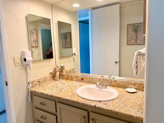 a bathroom with a granite countertop sink and a mirror