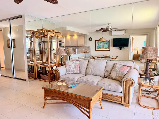 a living room with furniture a flat screen tv and a table