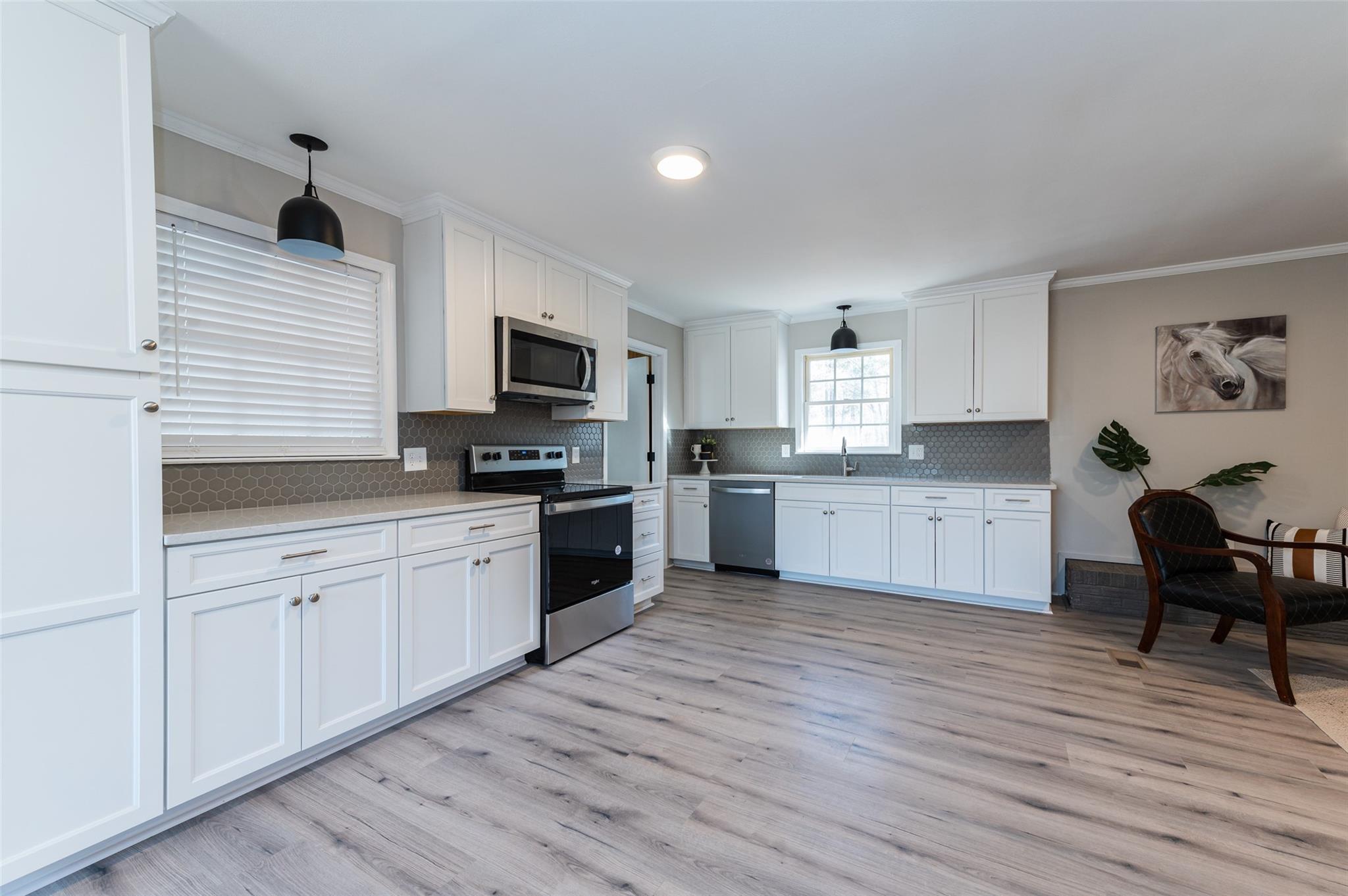 2715 Pineview Drive Lancaster, SC 29720 - Photo 11 of 40 a kitchen with granite countertop a stove top oven a sink dishwasher a dining table and chairs with wooden floor