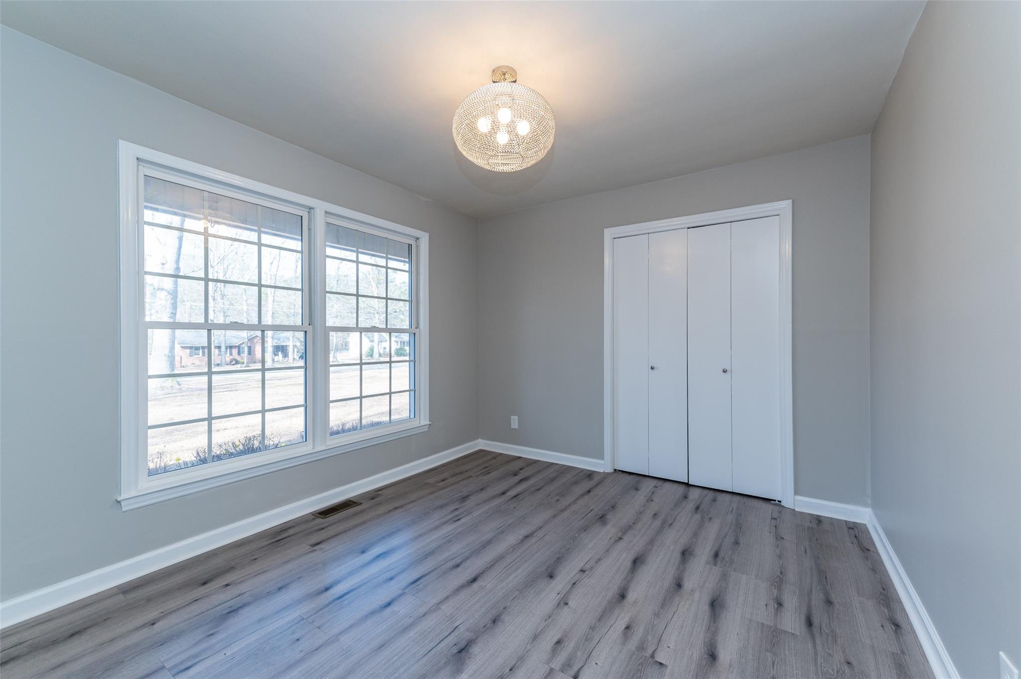2715 Pineview Drive Lancaster, SC 29720 - Photo 16 of 40 an empty room with wooden floor and windows