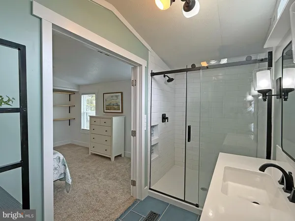 a bathroom with a sink and glass door shower