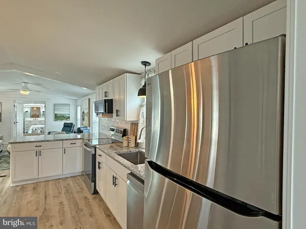 a kitchen with stainless steel appliances a refrigerator sink and white cabinets