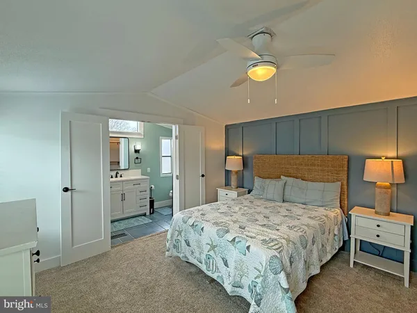 a bedroom with a bed and a lamp on dresser