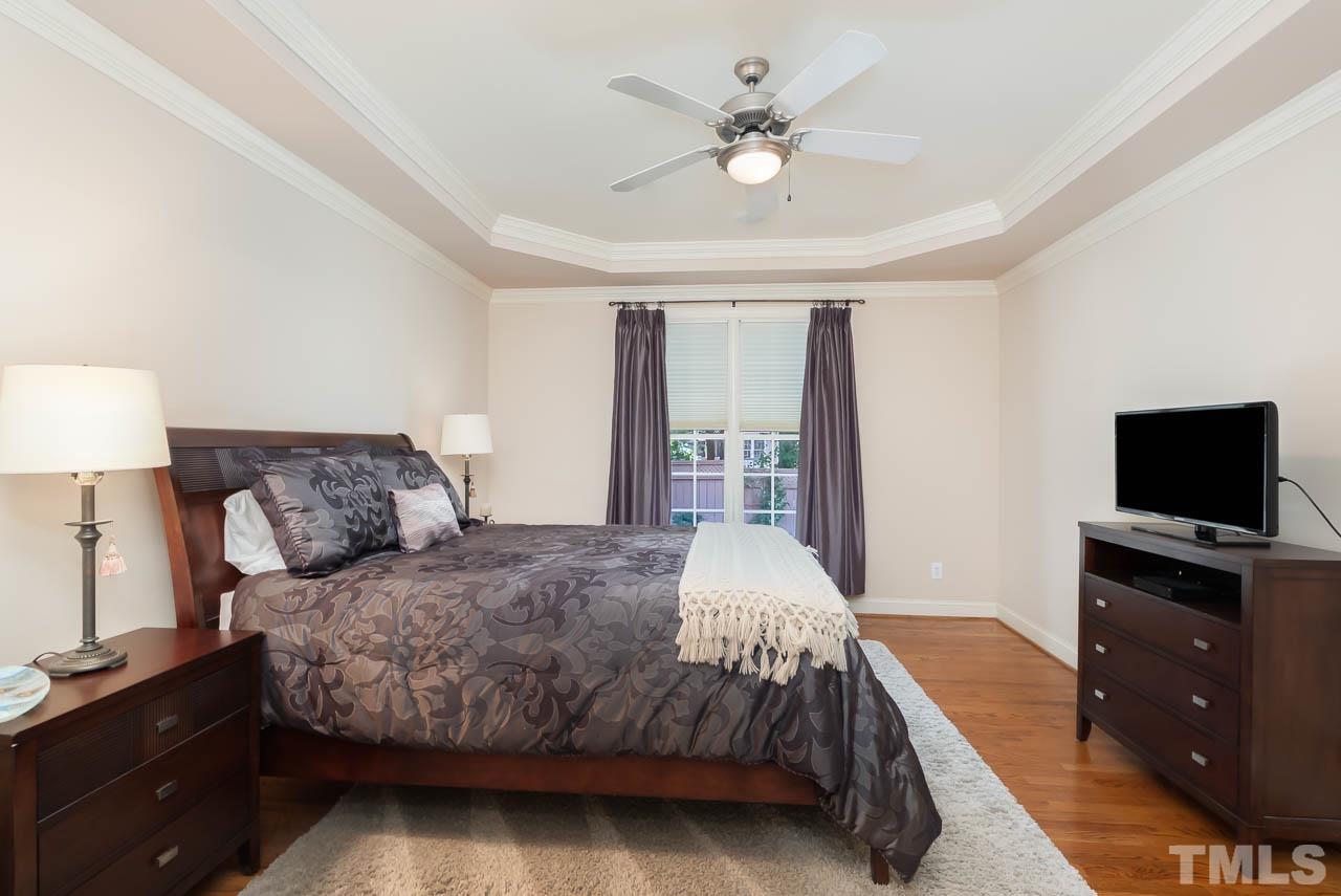 109 Nouveau Avenue Raleigh, NC 27615 - Photo 14 of 29 a bedroom with a large bed and a flat tv screen on a dresser