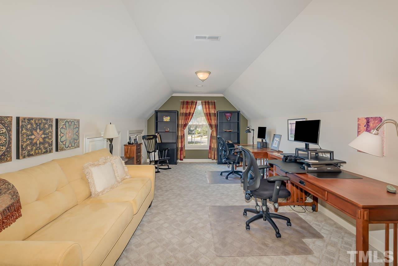 109 Nouveau Avenue Raleigh, NC 27615 - Photo 18 of 29 a living room with furniture a fireplace and a flat screen tv