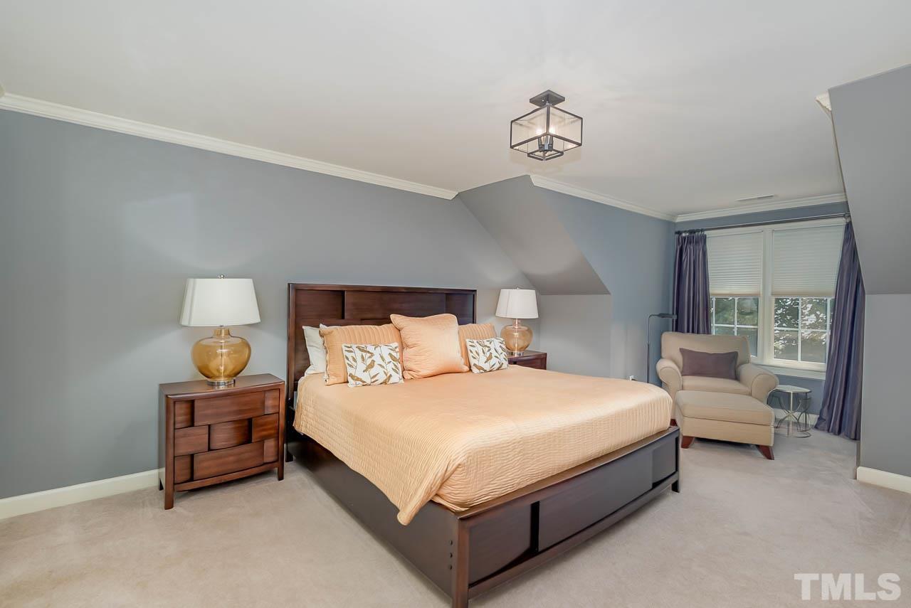 109 Nouveau Avenue Raleigh, NC 27615 - Photo 20 of 29 a bedroom with a bed and a chandelier